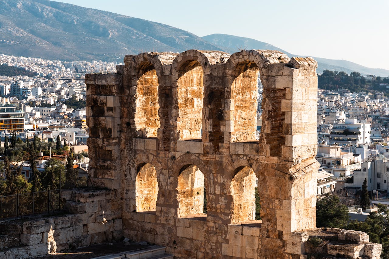 Ancient stone arches of the Odeon of Herodes Atticus theater overlooking the city of Athens, Greece.